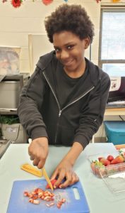 teen dicing strawberries