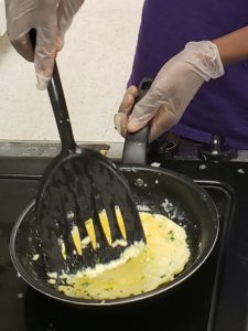 person cooking eggs