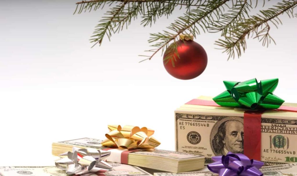 Holiday ornament on tree with money underneath